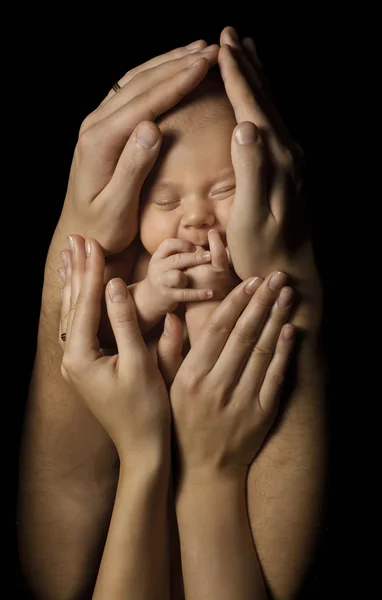 Baby in handen van de familie te houden nieuwe geboren kind, de ouders slapen pasgeboren — Stockfoto