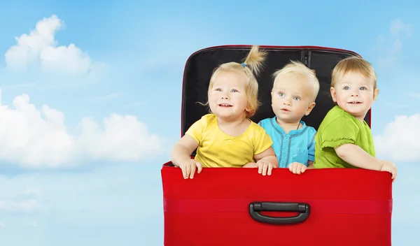 Bambini in valigia, tre bambini felici che giocano — Foto Stock