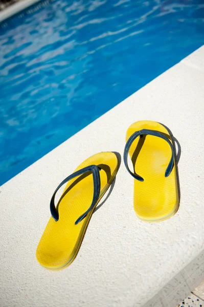 Sandálias velhas à beira da piscina — Fotografia de Stock