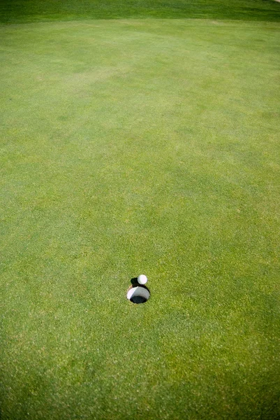 Bola de golfe pelo buraco — Fotografia de Stock