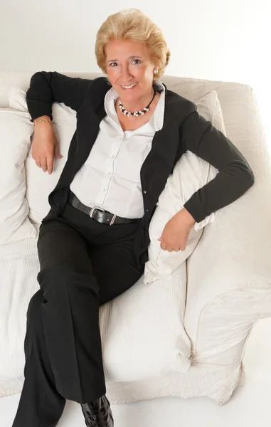 Senhora sorridente em um sofá — Fotografia de Stock