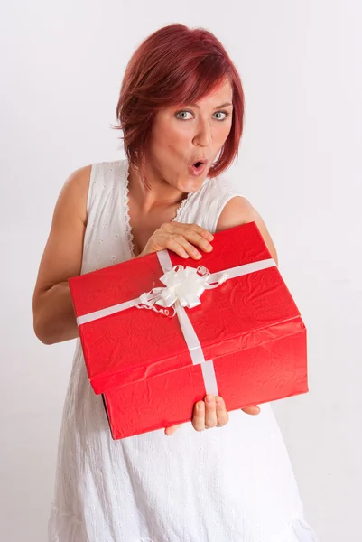 Femme à la tête rouge excitée ouvrant un cadeau — Photo