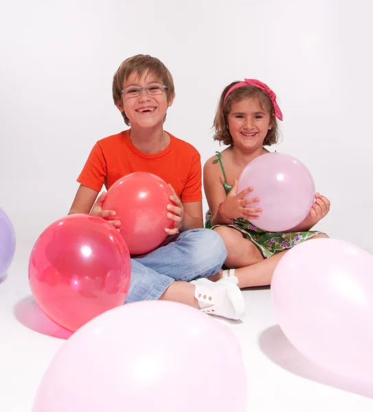 Мальчик и девочка играют с воздушными шарами — стоковое фото