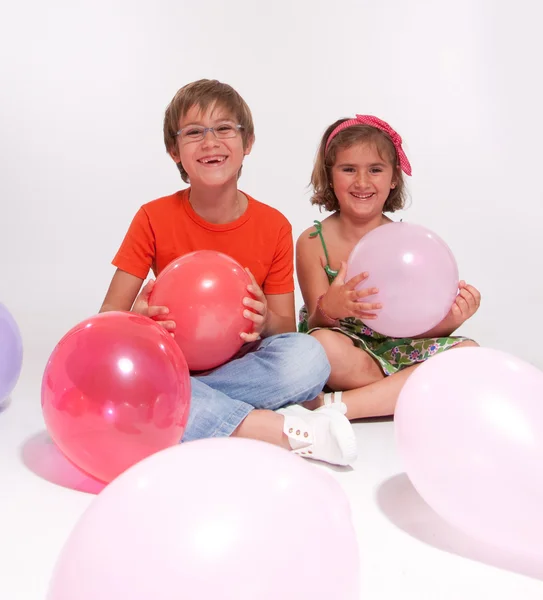 Garçon et fille jouant avec des ballons — Photo