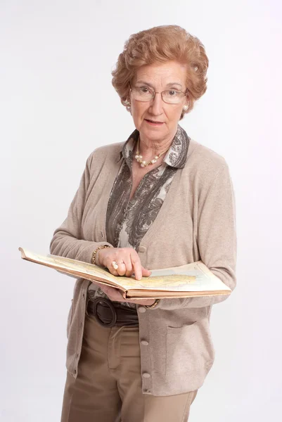 Senior dame wijzen een pagina in een boek — Stockfoto