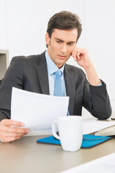 Serious Businessman reading a report — Stock Photo, Image