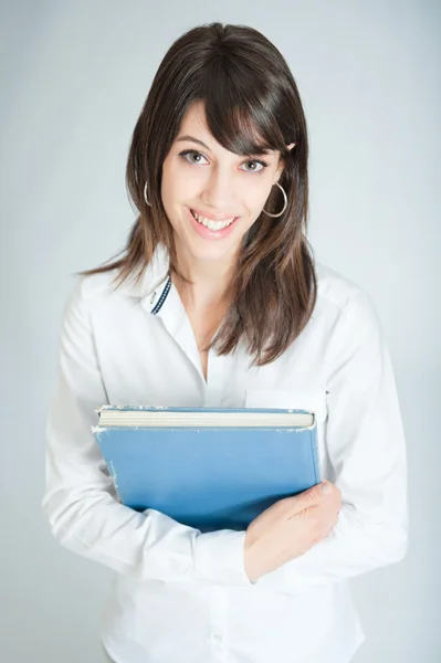 Uśmiechnięta brunetka w białej koszuli książką — Zdjęcie stockowe