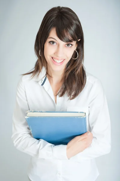 Sonriente morena en camisa blanca sosteniendo un libro —  Fotos de Stock