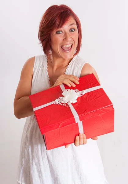 Menina de cabeça vermelha feliz abrindo um presente — Fotografia de Stock