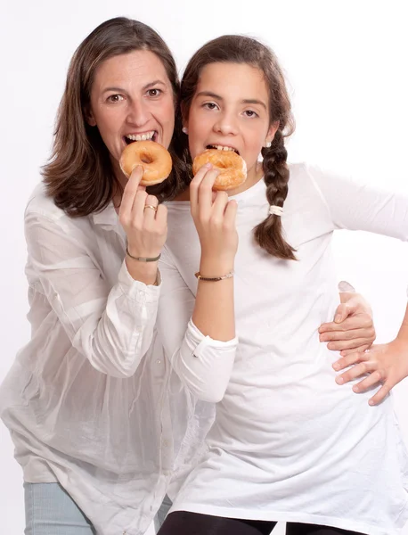 Mãe e filha comendo donuts — Fotografia de Stock
