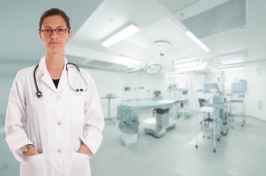 Serious female doctor in operating room clipart
