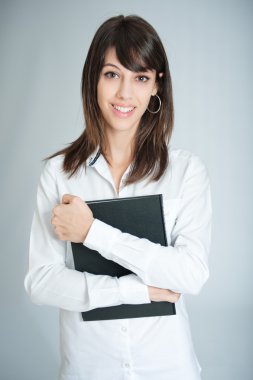 Kara kitap tutan beyaz gömlek gülümseyen esmer