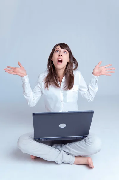 Junge Frau mit Laptop auf dem Boden und Blick nach oben — Stockfoto