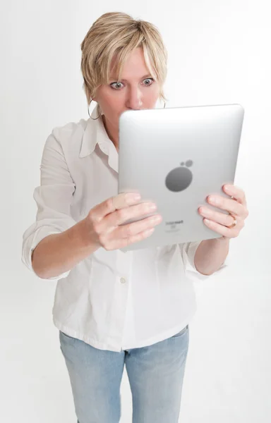 Verblüffte Frau liest vom PC-Tablet — Stockfoto