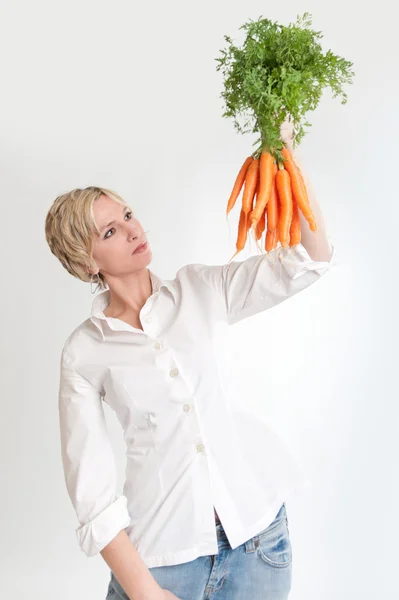 Жінка дивиться на купу моркви — стокове фото