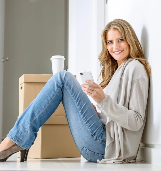 Happy woman texting in new home — Stock Photo, Image