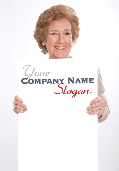 Vrolijke senior dame houden een verticale leeg bord — Stockfoto