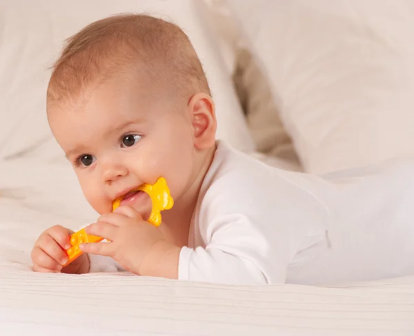 Baby beißt mit gelbem Spielzeug — Stockfoto