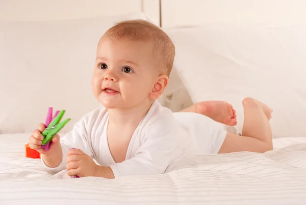 Baby innehav färgglada pinnar — Stockfoto