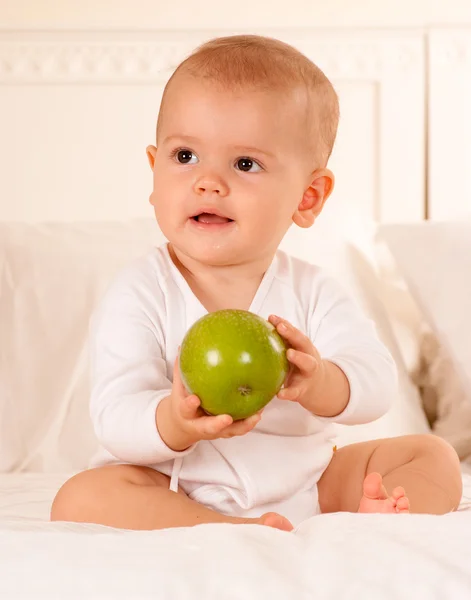 Baby manipulera grönt äpple — Stockfoto