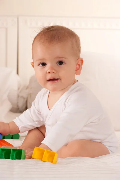 Bambino che gioca su un letto — Foto Stock