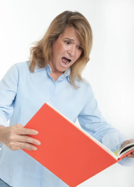 Mulher em pânico examinando um livro — Fotografia de Stock