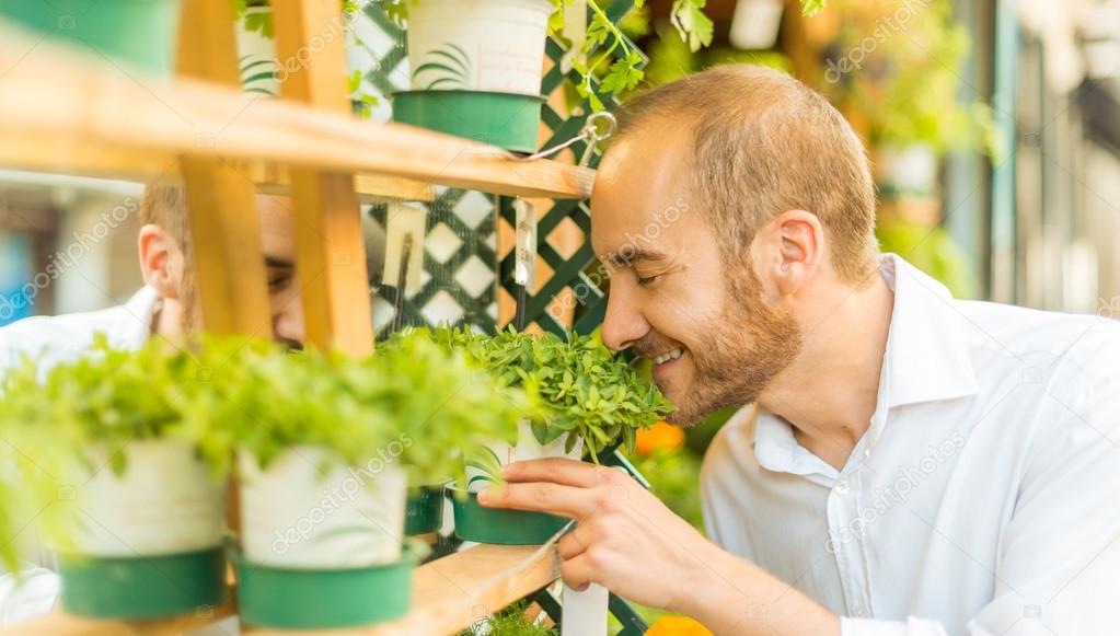 Man smelling herbs in a shop