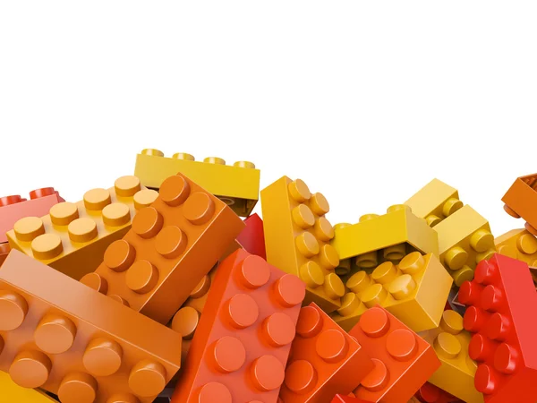Brinquedo de plástico tijolos fundo em cores quentes — Fotografia de Stock