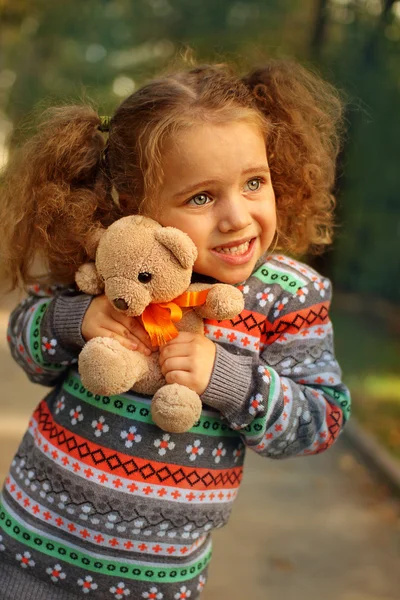 Meisje in park knuffelen een teddybeer — Stockfoto