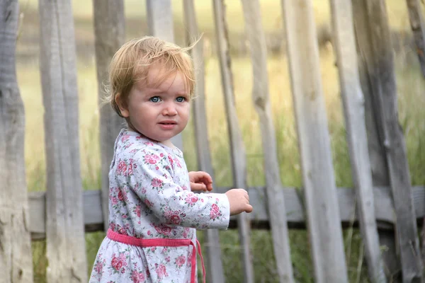 Baby toddler standing at the fence — Stock Photo, Image