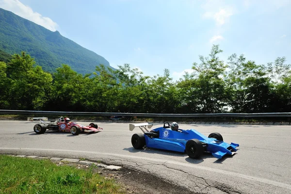 Een automerk van de F3, gevolgd door een rode Formule Ford neemt deel aan de Nave Caino Sant'Eusebio-race op juni 27, 2015 in Caino (Bs). De auto's werden gebouwd in 1979 en 1975. Rechtenvrije Stockafbeeldingen