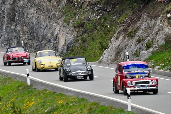 Einen roten volvo pv544, einen dunkelgrünen daimler sp250, einen gelben porsche 356 und eine rote alfa romeo giulia spinne — Stockfoto