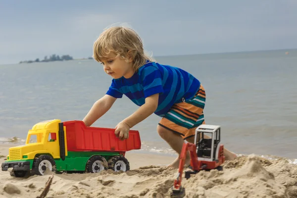 Bambino che gioca con i giocattoli sulla spiaggia — Foto Stock