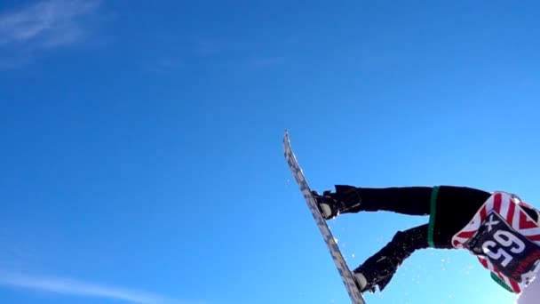 Snowboardista skákání proti modré obloze. — Stock video