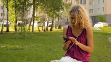 App üzerinde cep telefonu açık havada kullanan kadın.