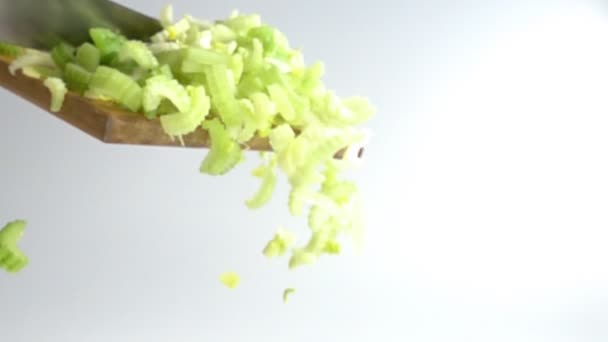 Fresh Cut Celery Pedaços caindo de tábua de madeira em câmera lenta — Vídeo de Stock