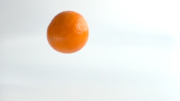 Una mandarina cayendo en cámara lenta — Vídeos de Stock