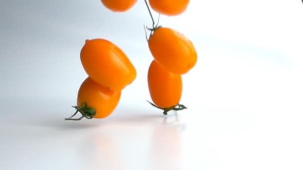 Tomates amarillos frescos en rama que cae en cámara lenta — Vídeos de Stock