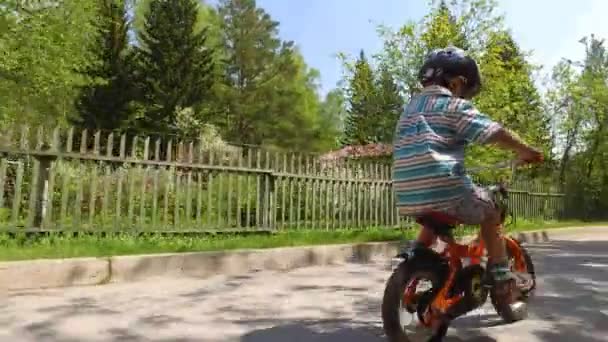 Roztomilé malé dítě jezdit na kole oranžové v parku — Stock video