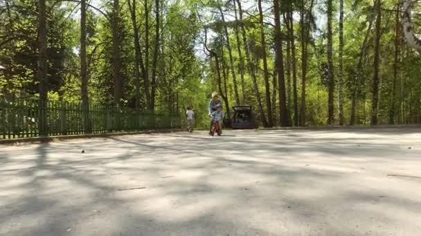 Мать помогает сыну ездить на велосипеде — стоковое видео