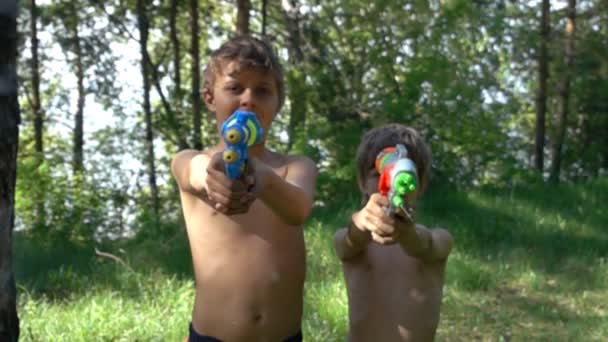 Kinder spielen Wasserpistolen im Freien — Stockvideo