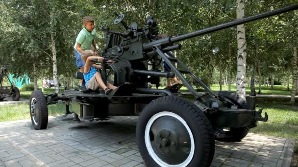 Boys playing on anti-aircraft gun World War II era — Stock Video