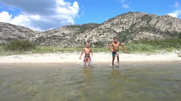 Παιδιά που τρέχουν στο νερό σε αργή κίνηση για τις καλοκαιρινές διακοπές — Αρχείο Βίντεο