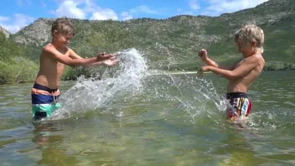 Boys playing in water lake. Summer fun. — Stock Video