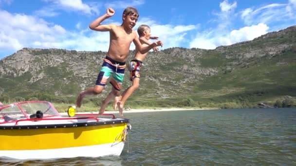Pojkarna hoppa i vattnet tillsammans i slow motion — Stockvideo