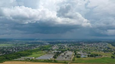 Hava manzarası. Altın tarla. Ufuktaki küçük kasaba. Kamera yukarı aşağı hareket ediyor. Bulutlardan yere. Finalde, yol kenarına iniyor..