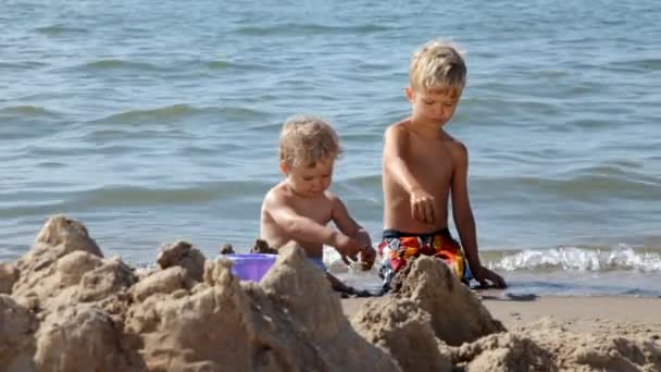 Enfants jouant dans un sable sur la plage . — Video