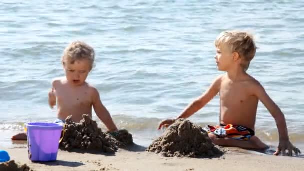 Primer plano de los niños construyendo castillos en la arena — Vídeo de stock