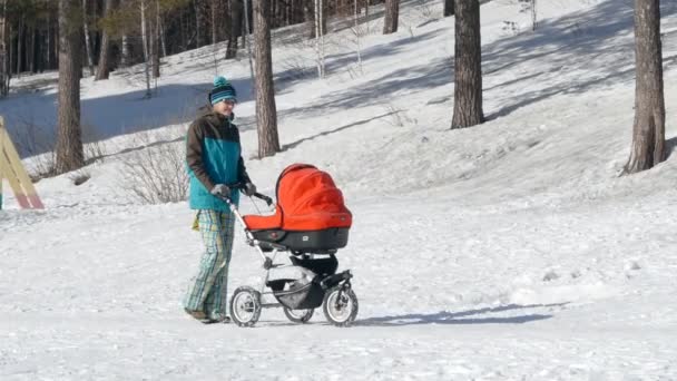 Beautiful young woman pushing baby carriage — Stock Video