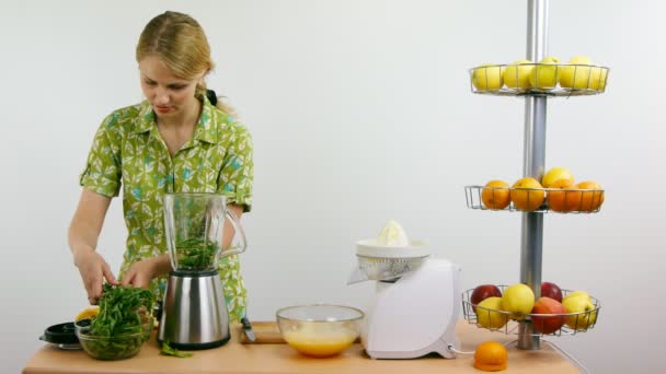 Vrouw maken groene fruit smoothie met blender. — Stockvideo